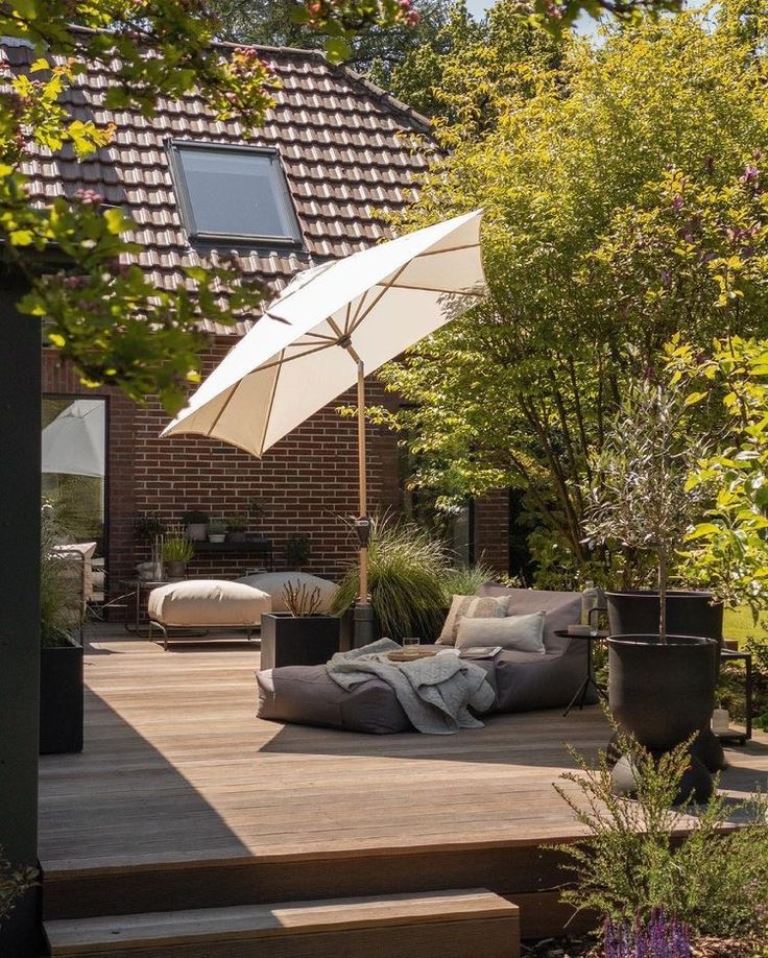 The deck at the house is styled beautifully: there's some contemporary furniture, plants with grasses and an umbrella.
