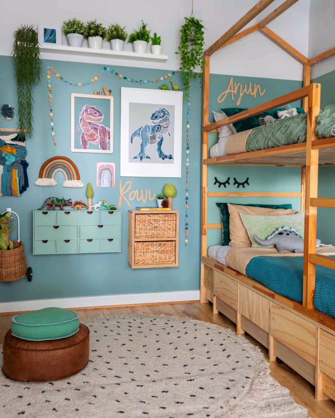 A fun and nature-inspired room featuring wooden bunk beds, jungle-green bedding, and wall-mounted dinosaur art. String garlands and macrame details add texture to the space. (@boysroominspo).