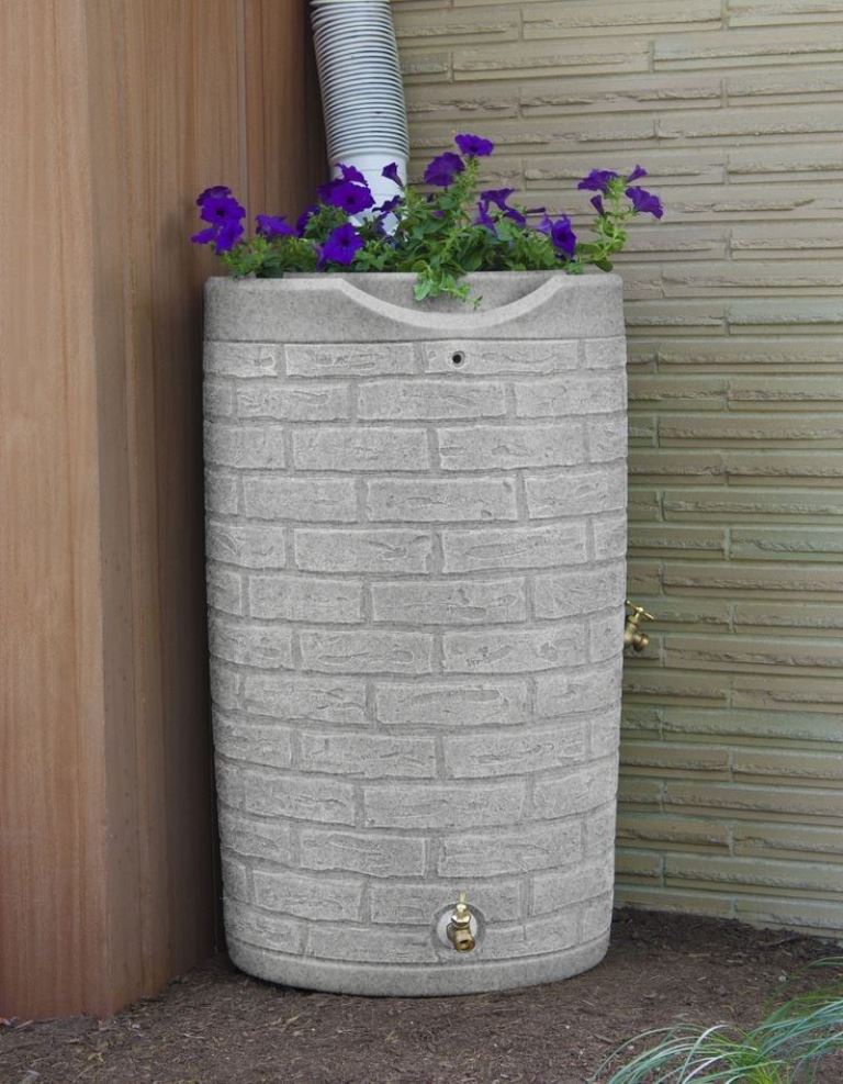 This faux brick barrel matches the wall and the bright blooms on top refresh the nook.