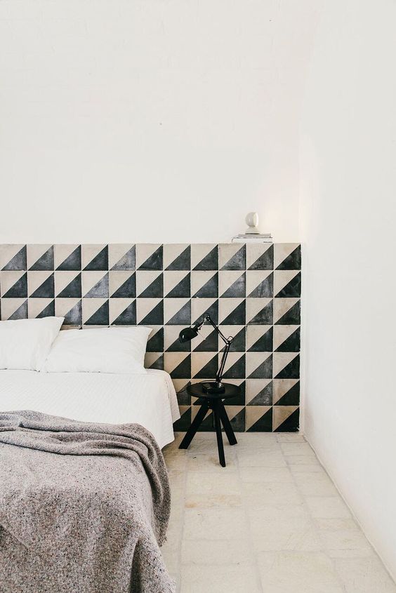 The bedroom is made unique with a geometric tile extended headboard with its geo print and unique material used.