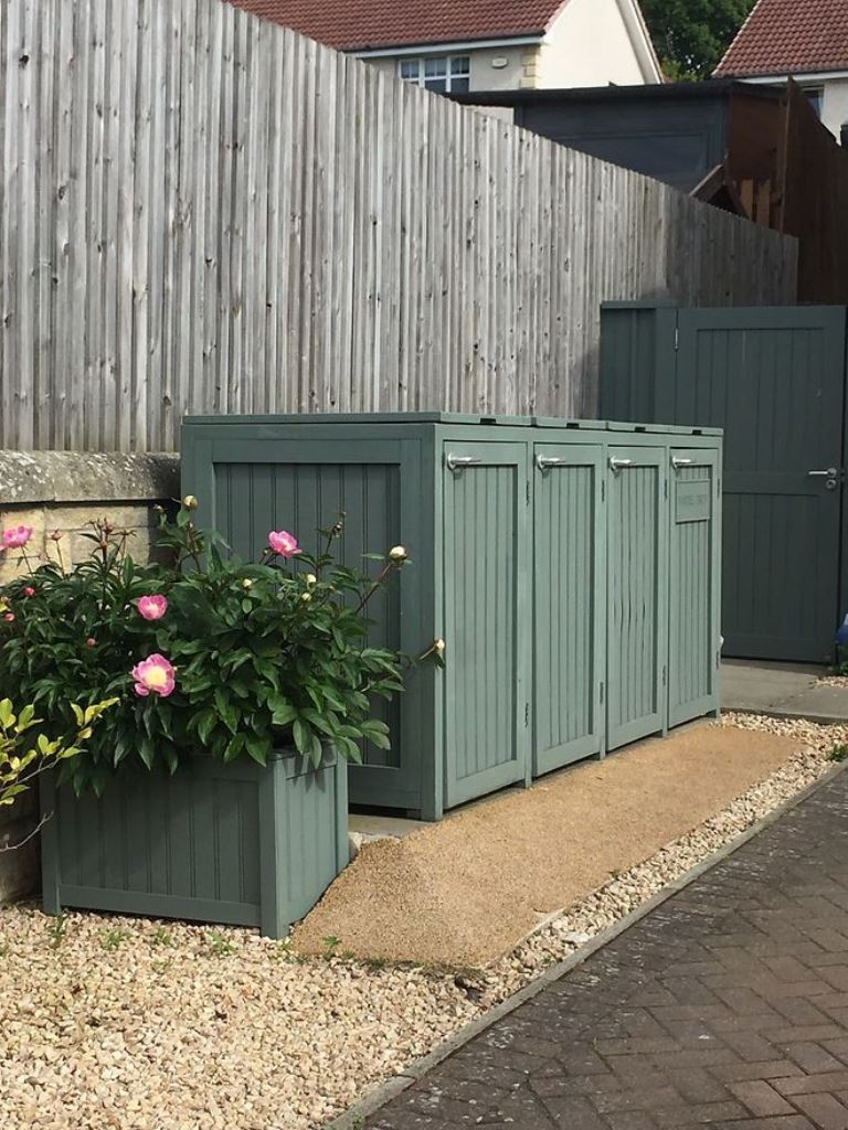 This large green box has several compartments for the trash cans and a matching planters makes the nook cooler.