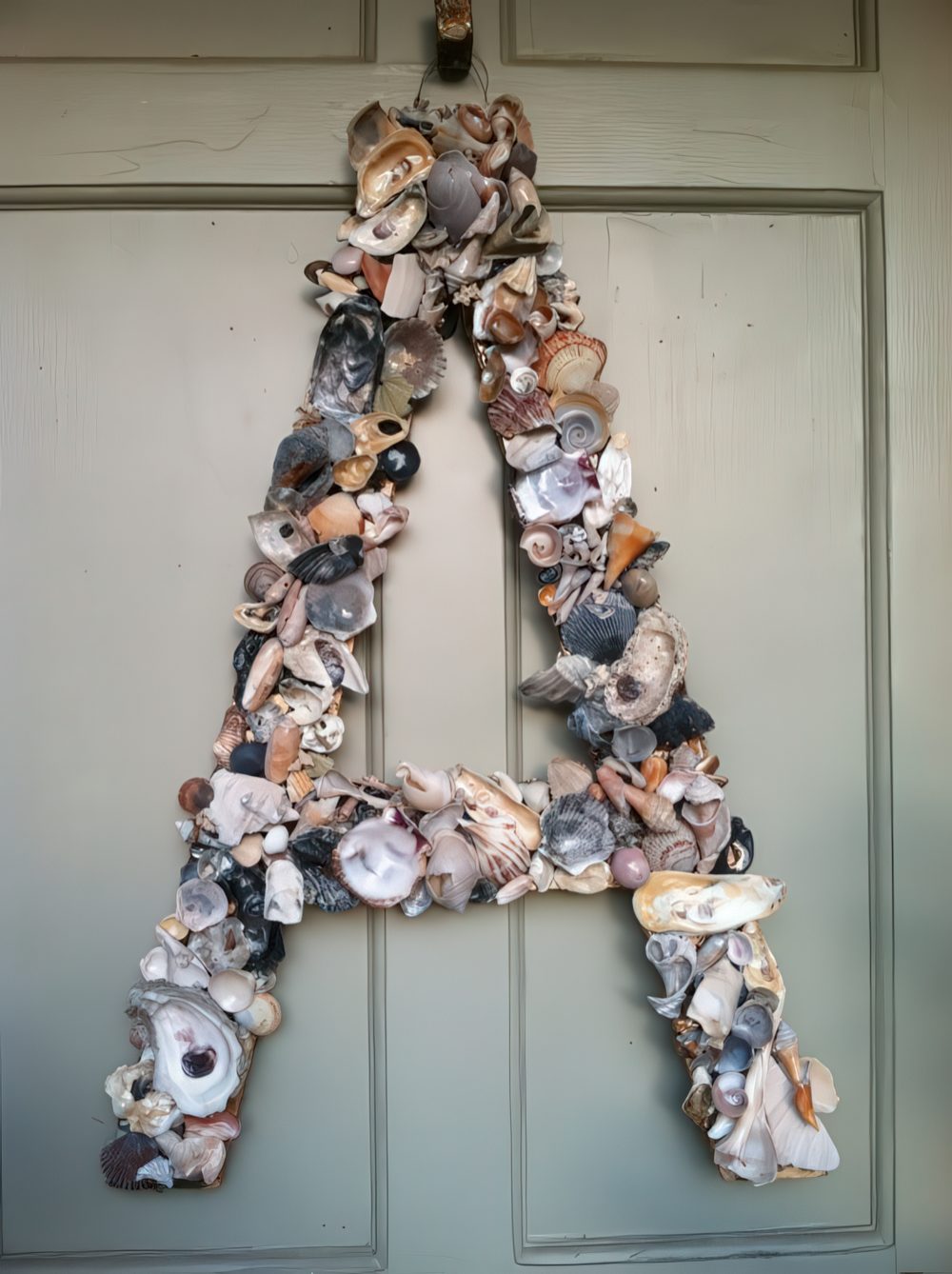 Accent your front door with a large monogram made of seashells - a perfect idea for a coastal home or for summer.