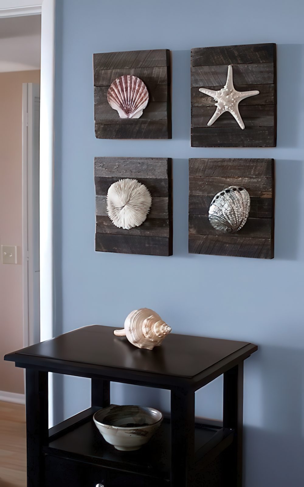Reclaimed wooden plaques with starfish and seashells make up a cool sea-inspired and coastal-inspired gallery wall.