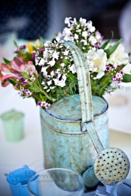 A vintage blue watering can with some wildflowers can be a nice decoration or centerpiece for any occasion.