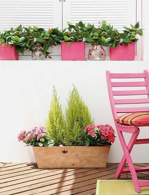 A plywood box with greenery and pink blooms is a cool summer decoration for outdoors or for a farmhouse space.