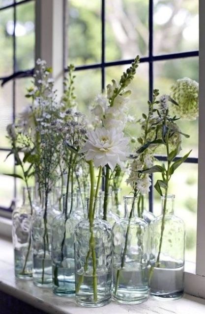 A stack of clear bottles with white blooms will give an ethereal and airy touch to your space, with a boho feel.