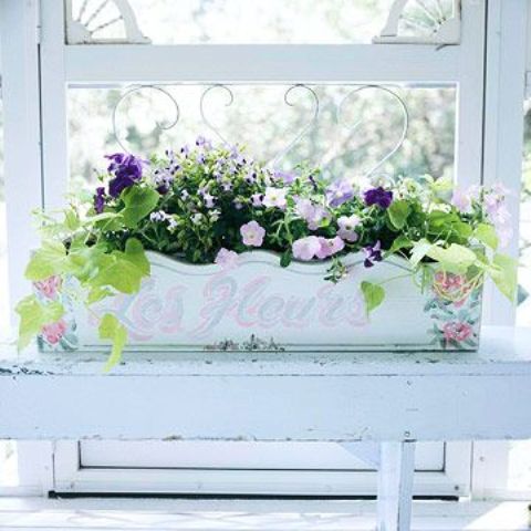 A vintage painted windowsill planter with summer blooms will decorate your window both indoors and outdoors.