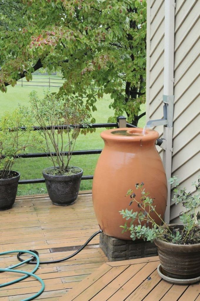 A large outdoor pot was turned into a rain water container to add chic to the space.