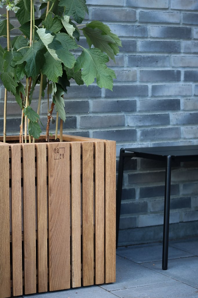 This minimalist slatted planter with greenery is a perfect solution for a contemporary space.