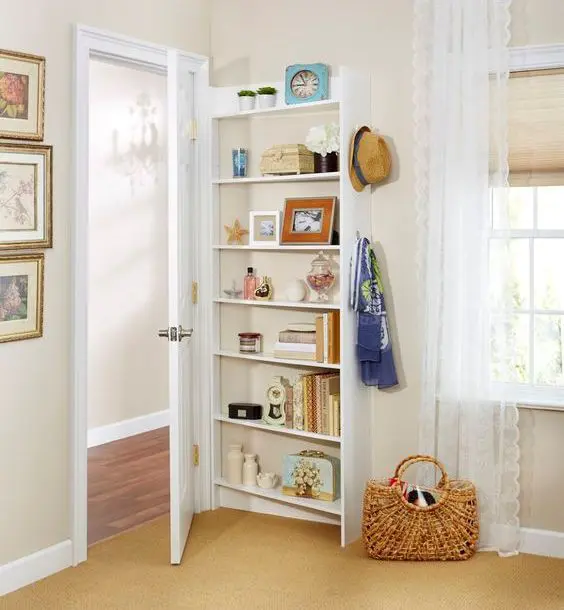 This tall narrow shelving unit shows off much decor and some books and clocks.