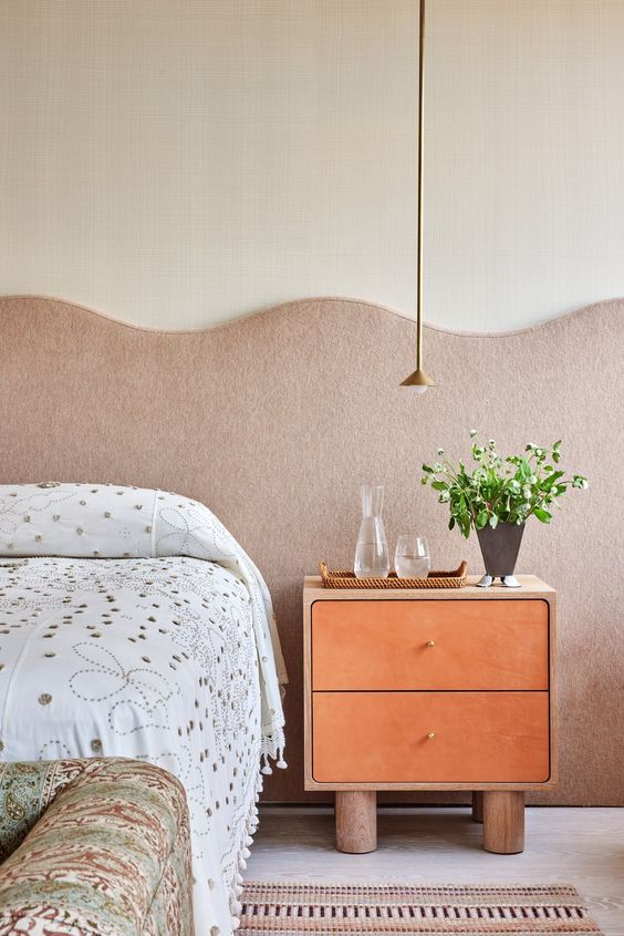 The whimsy bedroom is done with a wide tan wavy headboard, waves and scllops are very much in trend right now.