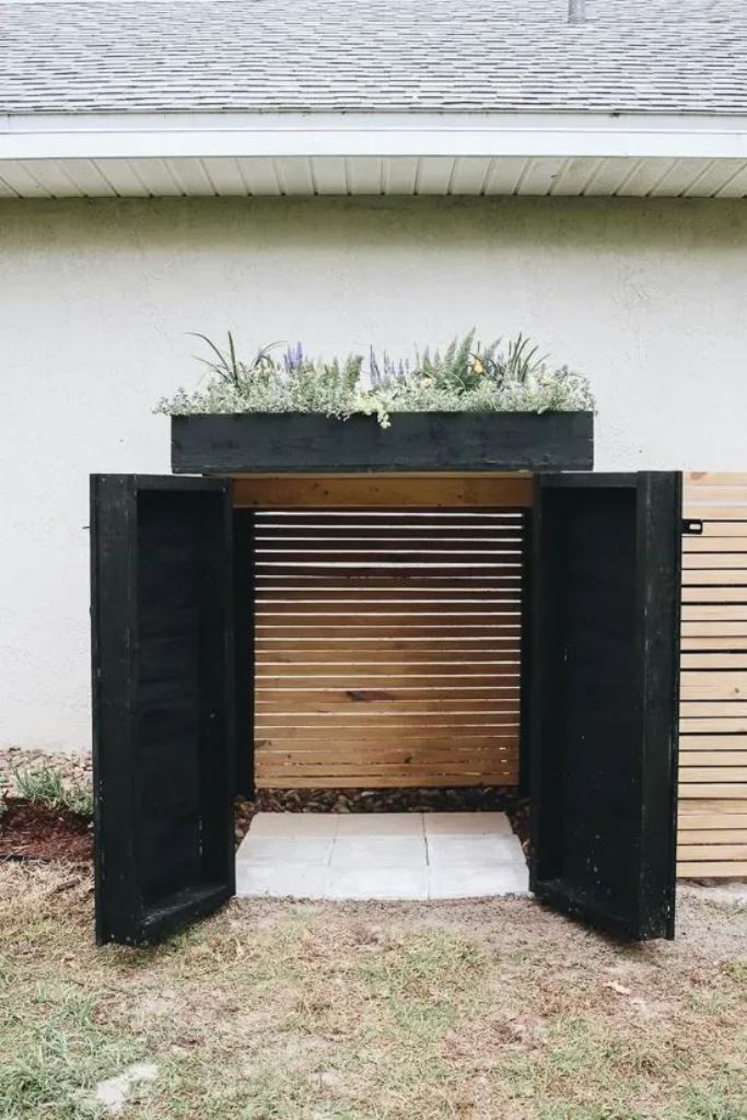This slatted cabinet with black doors and a black trey with plants will be a lovely AC cover.

(via withinthegrove).