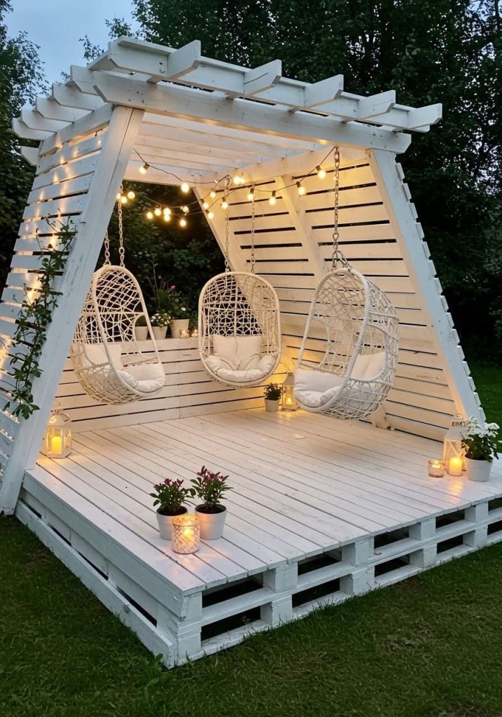 The unique white pergola is done with three egg-shaped chairs and lights, it's an ultimate garden spot.