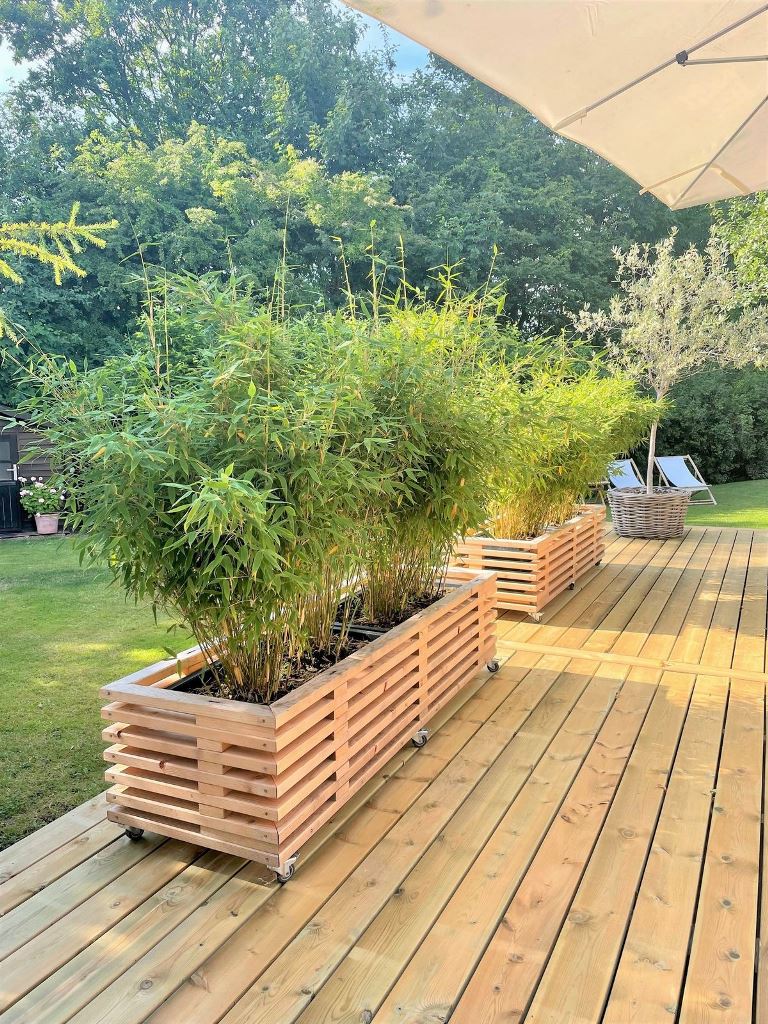 These slatted planters with casters and greenery are a lovely space divider.