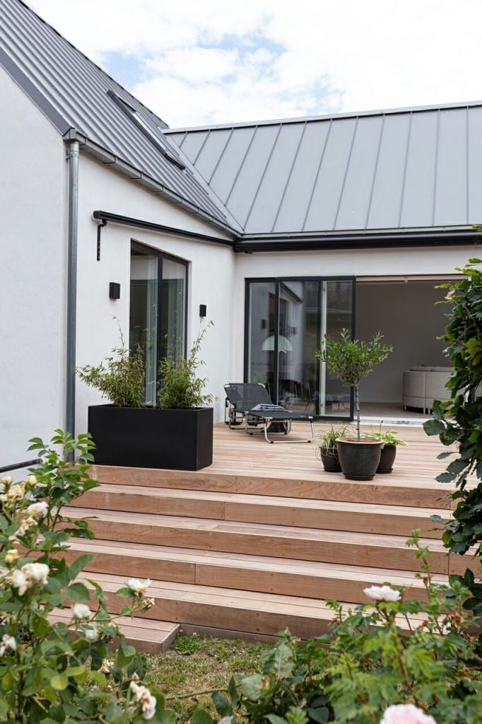 The raised deck is styled with black plants and a lounger to keep up the Scandinavian style of the house.

(via m4arkitekter).