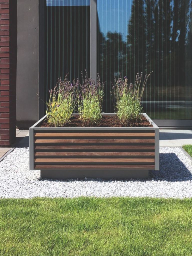 The raised garden bed with slatted edges adds a modern feel to the outdoor space.