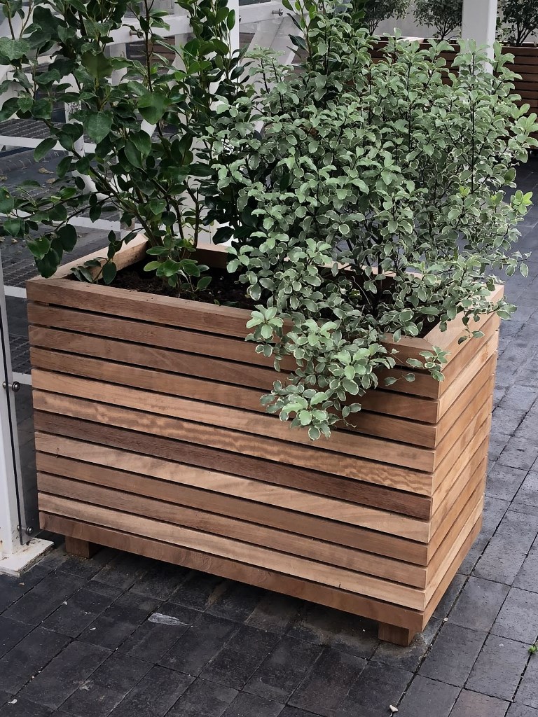 The rich-stained planter with greenery is a contemporary solution for a modern space.