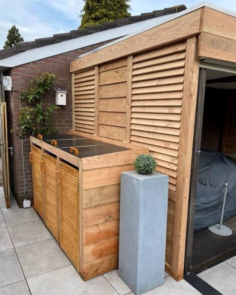 The stained box with shutter doors and a black lid is a stylish modern solution for outdoors.