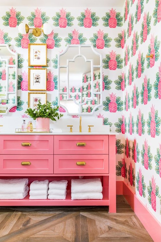 The whimsical pineapple wallpaper and bright pink color scheme in this bathroom screams Palm Beach.