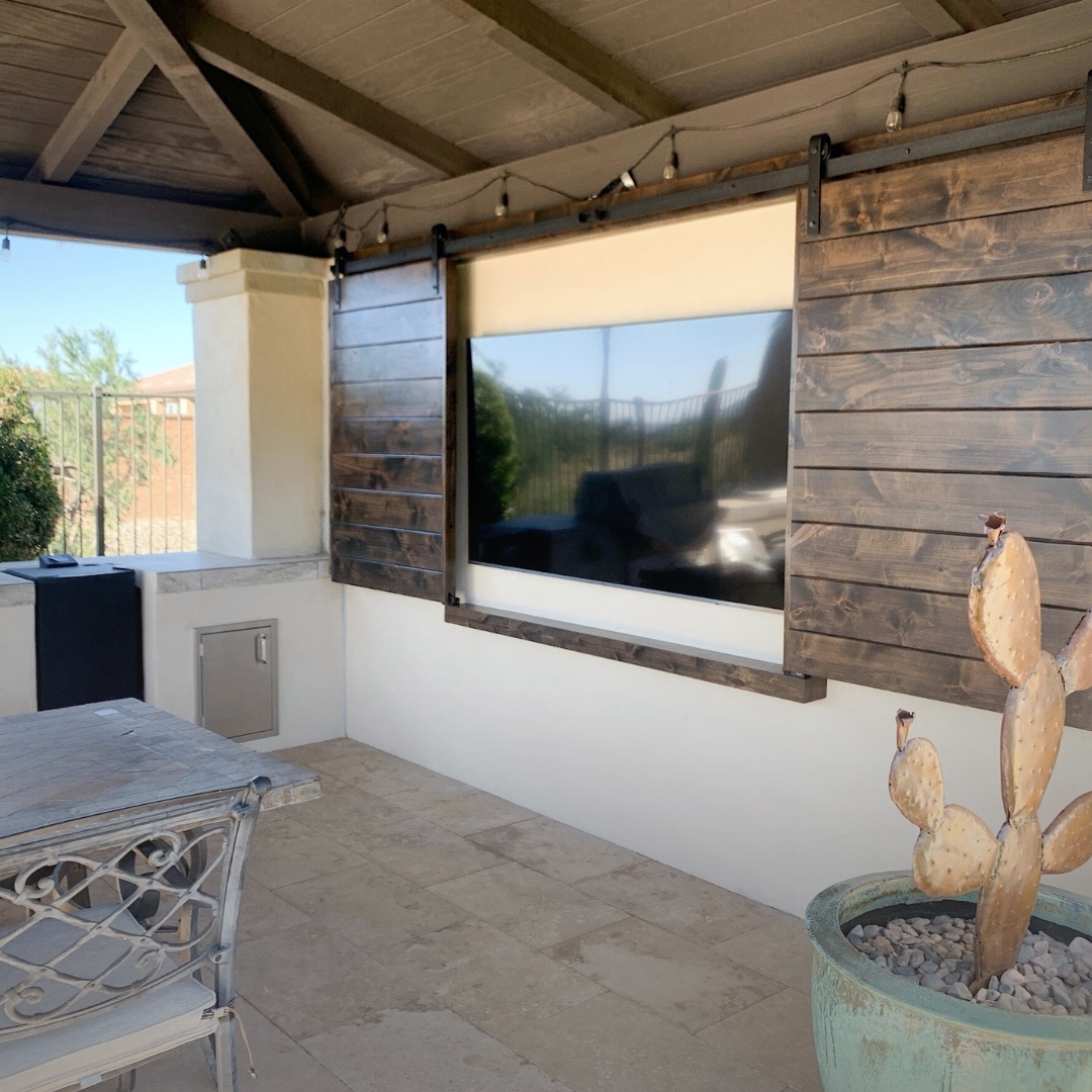 Rustic charm with a clever twist—sliding barn doors keep your outdoor TV safe and stylish when not in use.

(@thebarndoorstore).