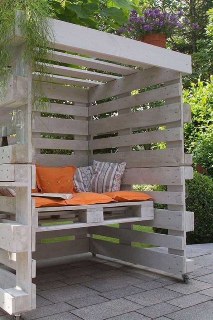 This small whitewashed arbor features casters, so you can move this roofed seat anywhere.