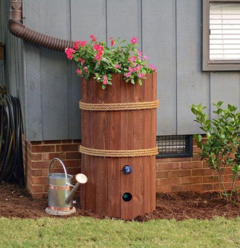 The barrel is clad with wood and rope, and bright blooms on top spruce up the space.