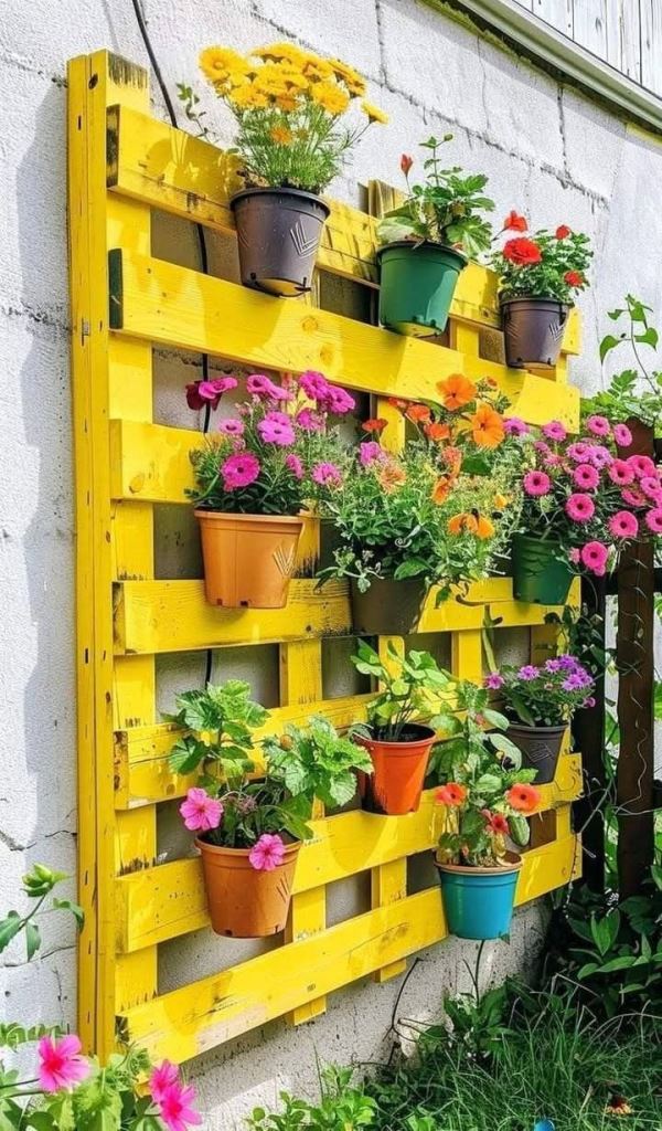 Paint the pallet the color you like, for example, sunny yellow to infuse your garden with color. Bright blooms will add even more of it.