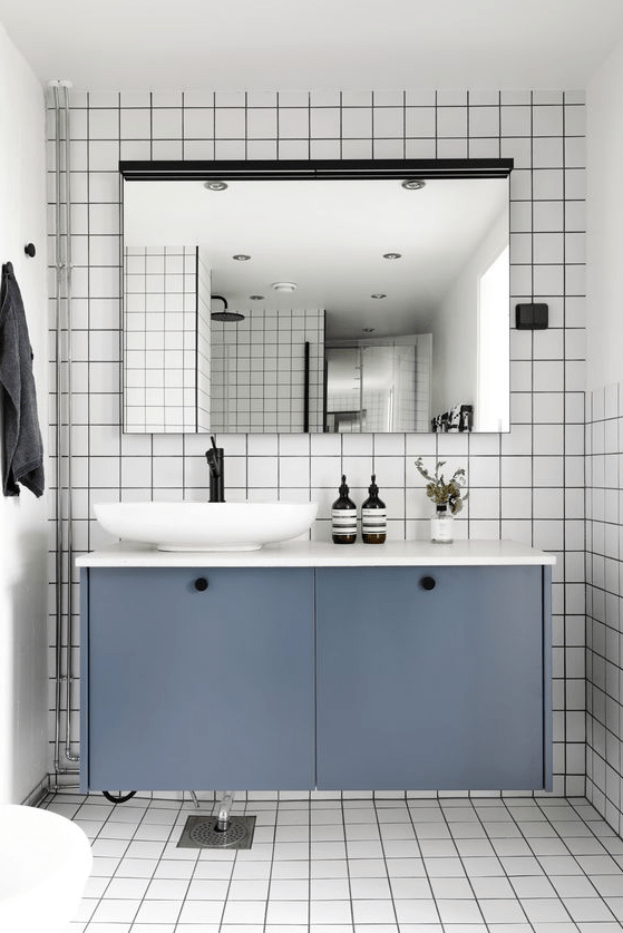 A floating bathroom vanity of an IKEA Metod cabinet with petrol blue paint and knobs is a stylish piece you can DIY.